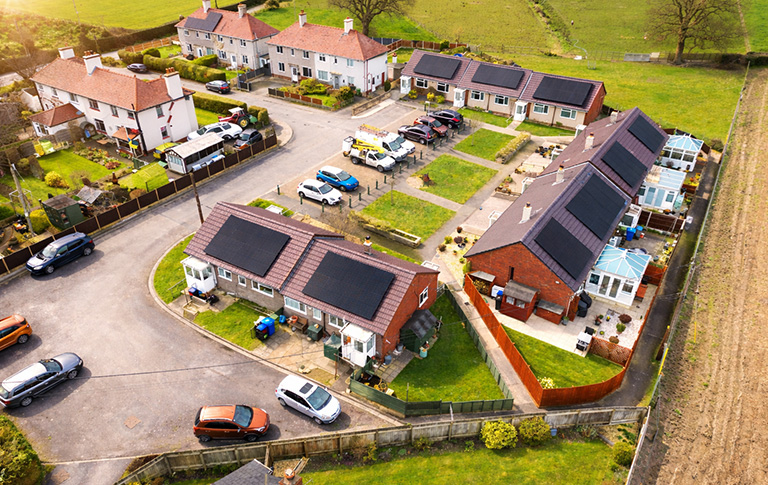 Aerial view of residential houses with solar panels installed on rooftops